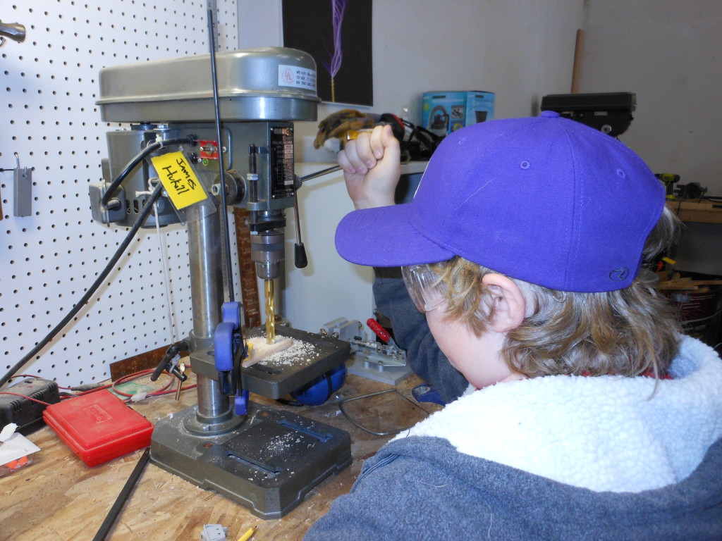 Quinn learns to use the drill press